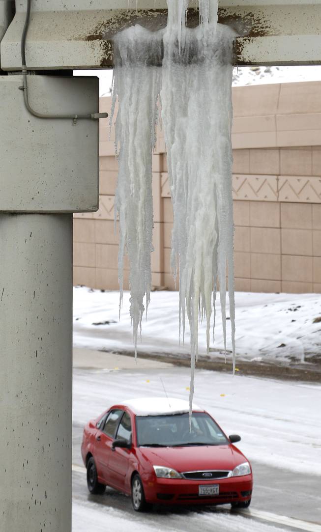 A large icicle hangs from a I-20 bridge near the new toll road crossing in Fort Worth. Cold and ice remained in Fort Worth, Texas, Sunday, Dec. 8, 2013 with roads especially treacherous in the the morning hours before temperatures rose. (AP Photo/The Fort Worth Star-Telegram, Paul Moseley)